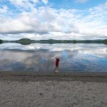 Ein Kind läuft am Ufer eines Sees.