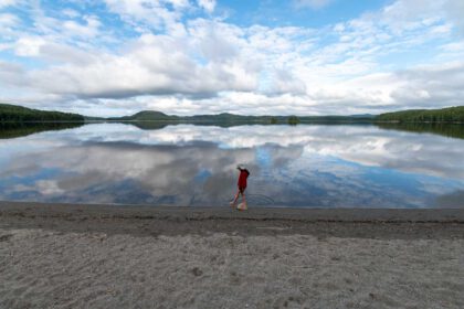 Ein Kind läuft am Ufer eines Sees.