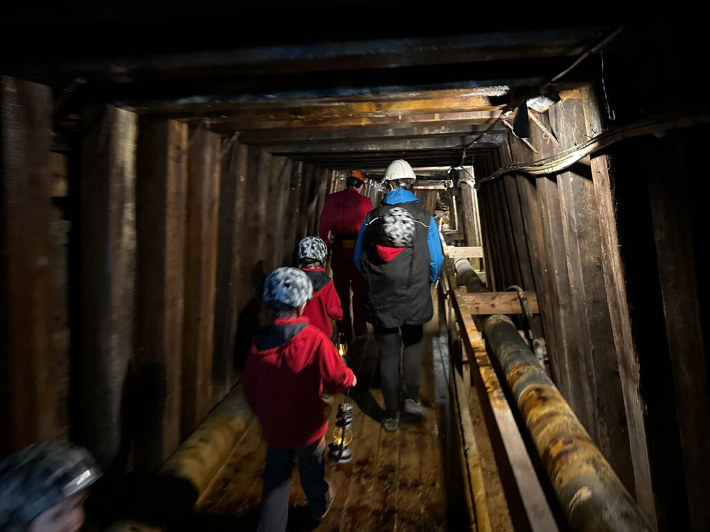 Menschen mit Helmen in einem Besucherbergwerk.