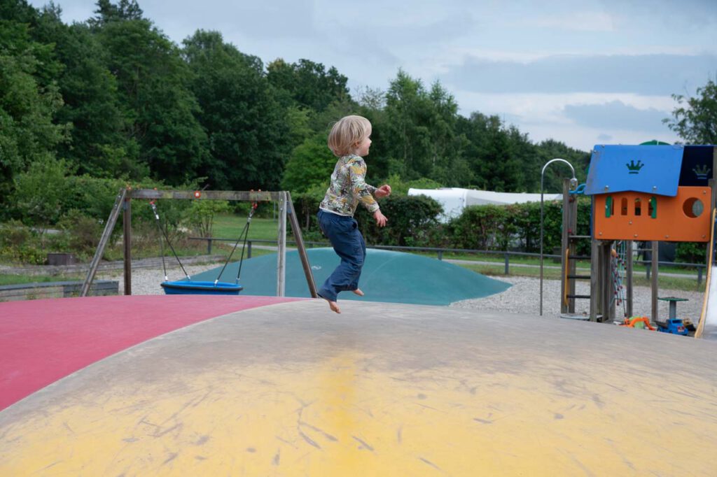 Kleines Kind springt auf Riesentrampolin.