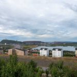 Blick auf Kiruna in Schweden, im Vordergrund Plattenbauten, dahinter die Abraumhalde des Bergwerks.