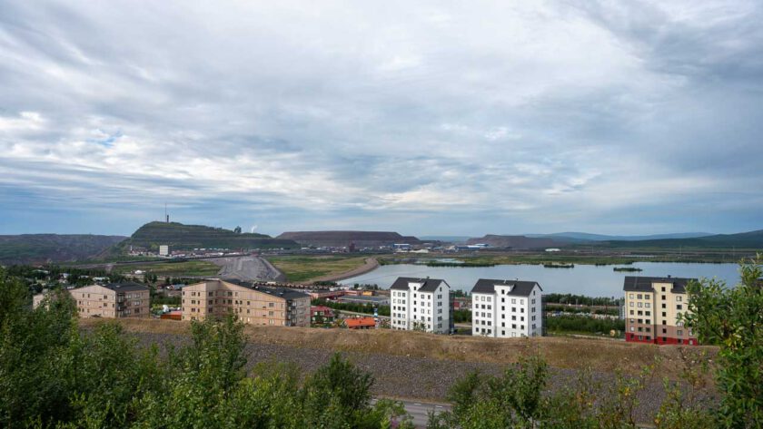 Blick auf Kiruna in Schweden, im Vordergrund Plattenbauten, dahinter die Abraumhalde des Bergwerks.