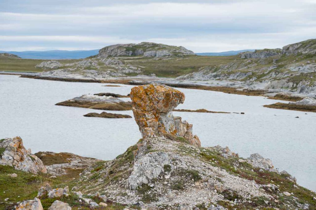 Eine ungewöhnliche Felsformation steht vor eine felsigen Bucht.