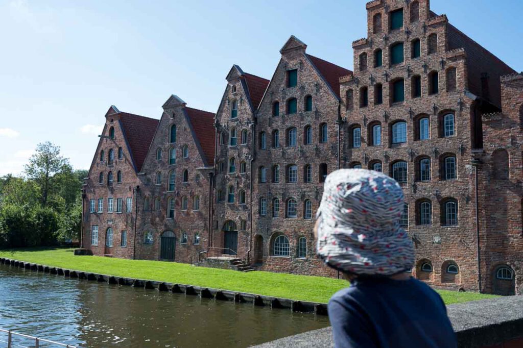 Häuserfassade in Lübeck mit dem Kopf eines Kindes im Vordergrund.