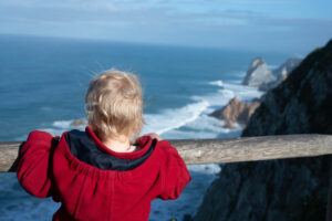 Kleinkind schau auf Meer und Klippen